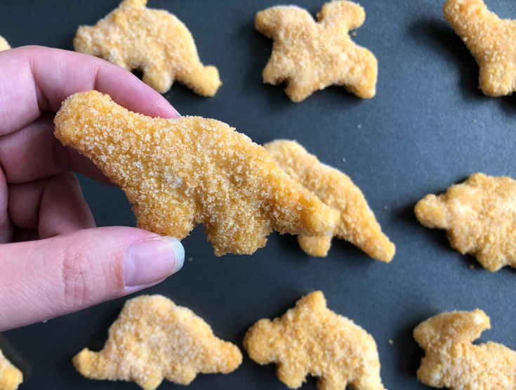 Yummy-Dino-Buddies-Holding-a-dino-shapped-chicken-nugget-Family-Fresh-Meals-.jpg